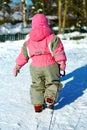 Little girl in overall Pulling sledges in winter