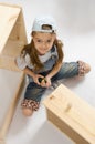 Little girl in overalls collector furniture spins screwdriver