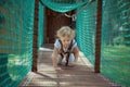 Little girl overcomes an obstacle in the rope park. Royalty Free Stock Photo