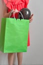 A little girl with a package in her hend enjoys shopping and sale on a light background. Child in good mood