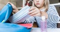 Little girl packing blue backpack in kids`s room. Face mask, bottle of sanitizer, stationery, pens, multicolored markers,