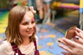 A little girl with a painted face looks at herself in the mirror at the party