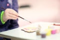 Little girl painting with brush wooden toy at home