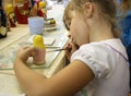 Little girl painting a matrioshka russian doll