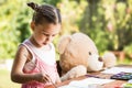 Little girl painting outdoor with her teddy bear friend Royalty Free Stock Photo