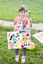 Little girl painting with paintbrush and colorful paints