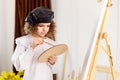 Little girl painting a picture in a studio or art school. Creative pensive painter child paints a colorful picture on Royalty Free Stock Photo