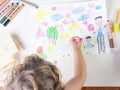 Little girl painting a pink dress of a girl in a kids drawing of Royalty Free Stock Photo