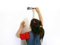 Little girl painting a wall