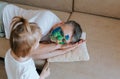 A little girl paints her father`s face with a brush and watercolors while he sleeps on the couch Royalty Free Stock Photo