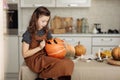 Little girl paints a pumpkin for Halloween. preparation for halloween. Halloween holiday and family lifestyle background.