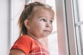 Little girl in pajamas looking out the window at the first snow Royalty Free Stock Photo