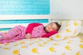 Little girl in pajamas lying in bed in the morning