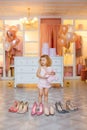 A little girl in pajamas put on high-heeled shoes for mom. The child is measuring his mother`s shoes Royalty Free Stock Photo