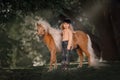 Little girl with palomino miniature horse in summer day