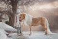 Little girl with palomino miniature horse in winter park Royalty Free Stock Photo