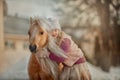 Little girl with palomino pony in winter park Royalty Free Stock Photo