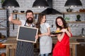 Little girl with parents cooking. Recipe of perfect family dinner. Mother and father with little girl holding chalkboard