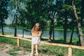 Little girl in the park near lake,depressed sitting on the bench Royalty Free Stock Photo