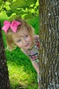 Little girl peaking around tree Royalty Free Stock Photo