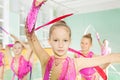 Little girl perform gymnast exercise in group