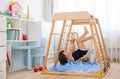 Little girl performs gymnastic exercises on a wooden home sports complex Royalty Free Stock Photo