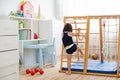 Little girl performs gymnastic exercises on a wooden home sports complex Royalty Free Stock Photo