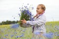Little girl picking blue flowers