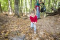 Little girl picking chestnuts in forest in autumn near mother Royalty Free Stock Photo