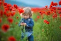 Little girl picking poppies in a field Little girl poppy field, jeans.Hiding in flowers cute beauty child Royalty Free Stock Photo