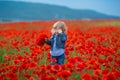 Little girl picking poppies in a field Little girl poppy field, jeans.Hiding in flowers cute beauty child Royalty Free Stock Photo