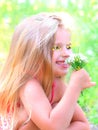 Little girl picking summer flowers in a field. Happy child enjoying nature outdoors. Sunlit  little girl smelling summer flowers. Royalty Free Stock Photo