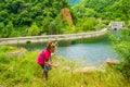 Little girl picks dry flowers at mountain reservoir edge Bulgaria