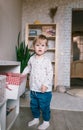 a little girl picks out a toy in a large white basket standing on the floor