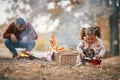 Girl on picnic playing while father preparing fire