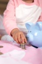 Little girl and piggy piggy bank fiddling with coins Royalty Free Stock Photo