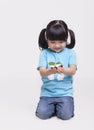 Little girl with pigtails in recycling symbol t-shirt holding a seedling, studio shot