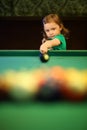 Little girl with pigtails starts the game of pool Royalty Free Stock Photo
