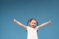 Little girl with pigtails in a white t-shirt shows gesture of approval to class