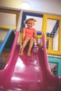 Little girl pin playground. Caucasian girl sliding on toboggan. Royalty Free Stock Photo