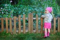 Little girl in pink boots near the fence Royalty Free Stock Photo