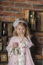 Little girl in a pink dress sitting on retro kitchen Royalty Free Stock Photo