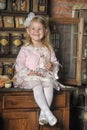 Little girl in a pink dress sitting on retro kitchen Royalty Free Stock Photo