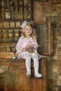 Little girl in a pink dress sitting on retro kitchen Royalty Free Stock Photo