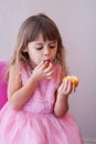 Little girl in pink fancy dress, eating sweet cupcake Royalty Free Stock Photo