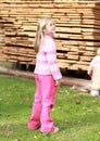 Little girl in pink in front of wood