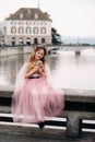 A little girl in a pink Princess dress with a bouquet in her hands walks through the old city of Zurich.Portrait of a girl in a Royalty Free Stock Photo