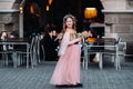 A little girl in a pink Princess dress with a bouquet in her hands walks through the old city of Zurich.Portrait of a girl in a Royalty Free Stock Photo