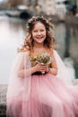 A little girl in a pink Princess dress with a bouquet in her hands walks through the old city of Zurich.Portrait of a girl in a Royalty Free Stock Photo