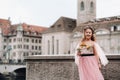 A little girl in a pink Princess dress with a bouquet in her hands walks through the old city of Zurich.Portrait of a girl in a Royalty Free Stock Photo